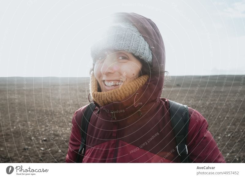 Frau in Winterkleidung lächelt und lacht in die Kamera, während sie Island besucht, am Strand von Sólheimasandur. Reisen nach Island, Road Trip Konzept. Kopieren Sie Raum Bild, besuchen Island.
