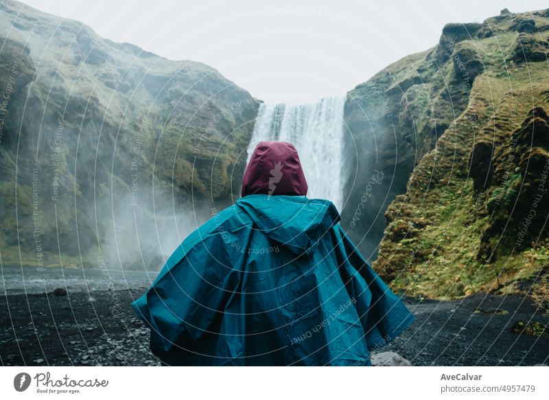 Frau auf regen Kleidung vor Skógafoss Wasserfall in Island während einer launischen Tag. Reisen auf van Konzept, Road Trip Stil. Besuchen Sie Island und nördlichen Ländern concept.Copy Raum Bild