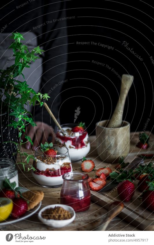 Chefkoch beim Kochen eines leckeren Desserts mit frischen Beeren in einer dunklen Küche Erdbeeren Käse Lebensmittel Hand Vitamin süß Person Gesundheit Scheibe