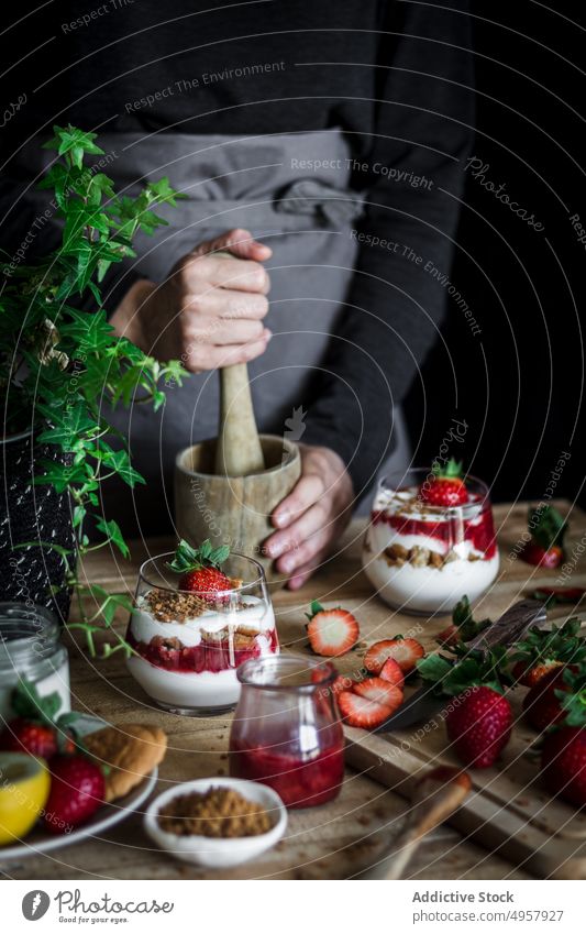 Chefkoch beim Kochen eines leckeren Desserts mit frischen Beeren in einer dunklen Küche Erdbeeren Minenwerfer Käse Lebensmittel Hand Vitamin süß Person