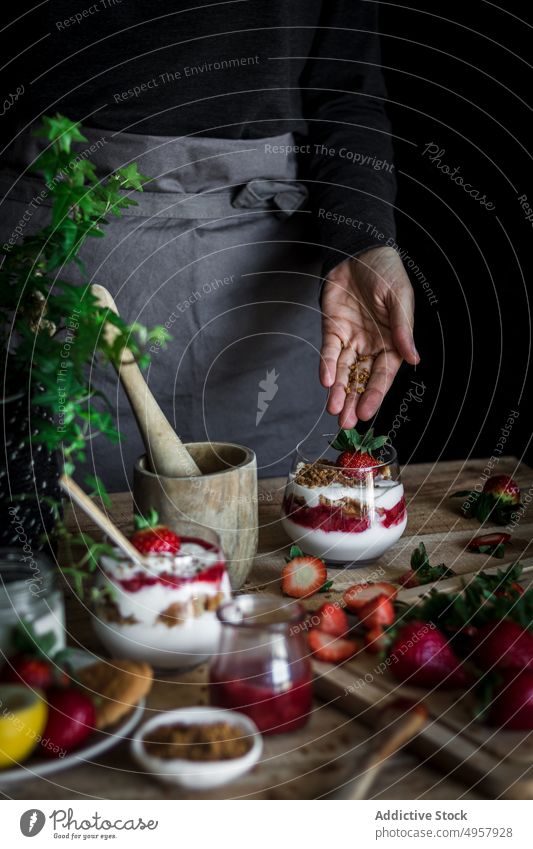 Chefkoch beim Kochen eines leckeren Desserts mit frischen Beeren in einer dunklen Küche Erdbeeren Käse Lebensmittel Hand Vitamin süß Person Gesundheit Scheibe