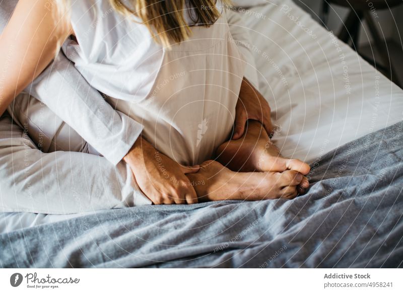 Anonymes Paar kuschelnd auf bequemem Bett in Wohnung Angebot Zuneigung Partnerschaft sich[Akk] entspannen Umarmen Liebe Umarmung Schlafzimmer Freundin sitzen