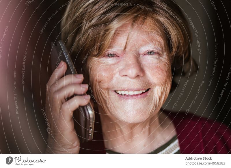 Ältere Frau beim Telefonieren zu Hause sprechen Smartphone heimwärts Anruf in den Ruhestand gehen Hautfalten ruhen Anschluss zuhören älter reif Mobile Senior