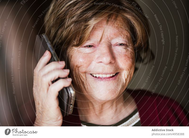 Ältere Frau beim Telefonieren zu Hause sprechen Smartphone heimwärts Anruf in den Ruhestand gehen Hautfalten ruhen Anschluss zuhören älter reif Mobile Senior