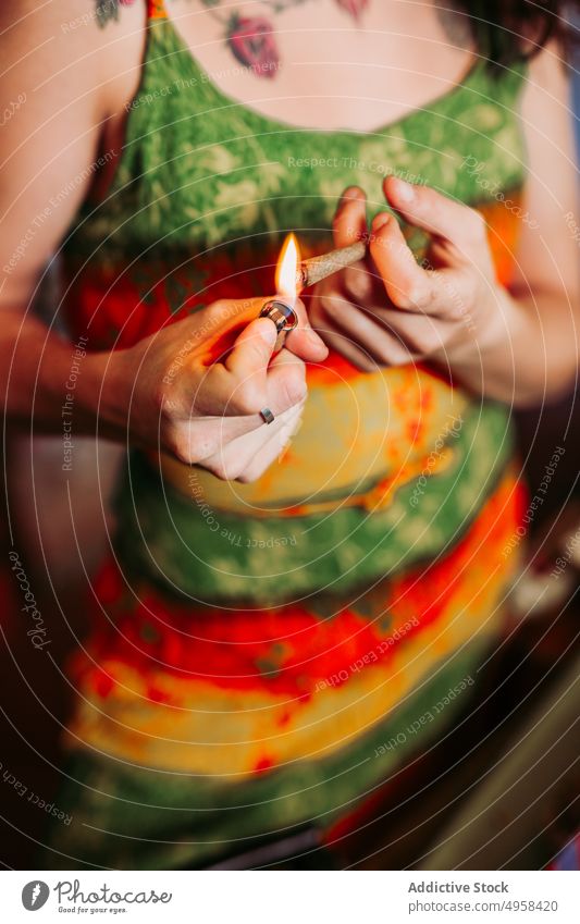 Lässig Anonyme Frau bereitet Joint mit Feuerzeug vor benutzend Unkraut Gelenk stumpf vorbereitend lässig jung Sucht Zigarette Freiheit Hipster