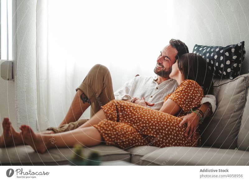 Lateinisches Paar, das sich zu Hause umarmt Erwachsener Raum Sitz Sofa Erholung Appartement attraktiv schön Liege Mode Gefühle Freunde Spaß Mädchen Freundin