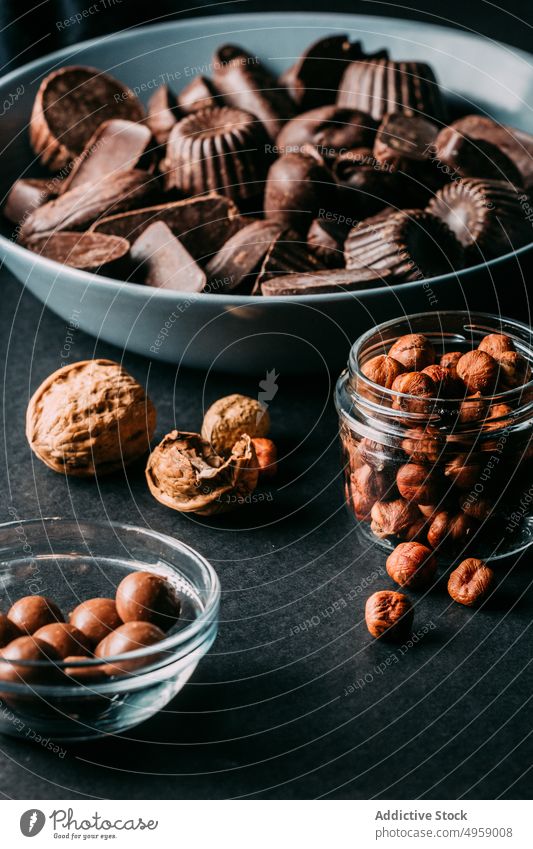 Leckere Schokoladenbonbons und Nüsse auf dem Tisch süß Dessert handgefertigt Walnussholz Haselnuss lecker Lebensmittel Kalorie Kakao Zusammensetzung