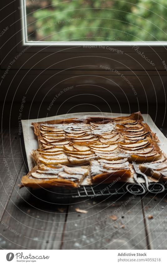 Apfelkuchen in Stücken auf Pergamentpapier serviert Pasteten frisch Holz rustikal Fenster Frangipane selbstgemacht Tageslicht braun Konditorei organisch warm