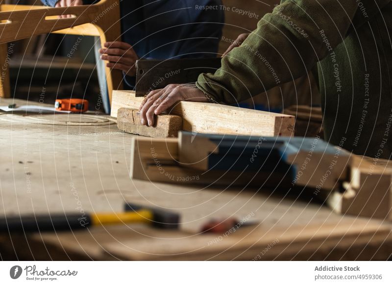 Tischler schneidet Holz mit Kollege Höhenmessung Männer Handwerker Säge messen Klebeband Tischlerarbeit Werkzeug Schreinerei männlich Handwerkskunst Stuhl