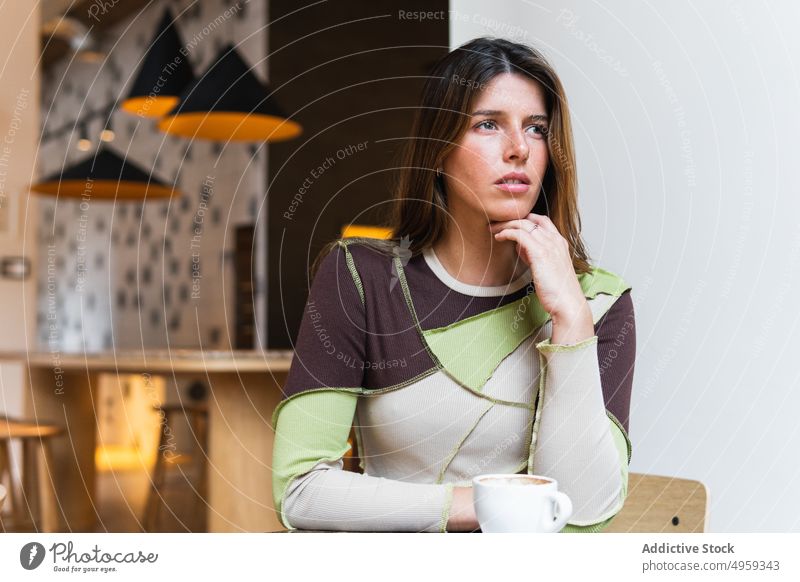 Nachdenkliche Frau mit einer Tasse Kaffee in einem Café Heißgetränk Getränk nachdenklich beschaulich charmant Aroma Kantine Porträt nachdenken feminin sanft