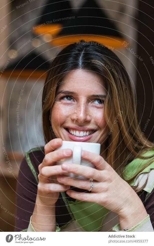 Nachdenkliche, fröhliche Frau mit einer Tasse Kaffee in einem Cafe heiter Heißgetränk Getränk beschaulich charmant Glück Aroma Kantine Porträt nachdenken