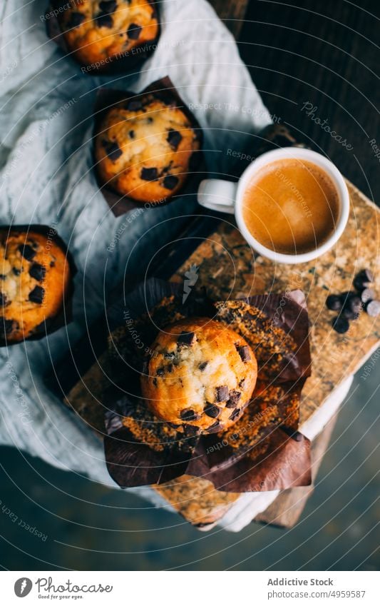 Schokoladenmuffins und Kaffeetasse auf dunklem Hintergrund gebacken Frühstück Butter Kuchen Tasse Cupcake dunkel Dessert Lebensmittel Muffin süß hölzern frisch