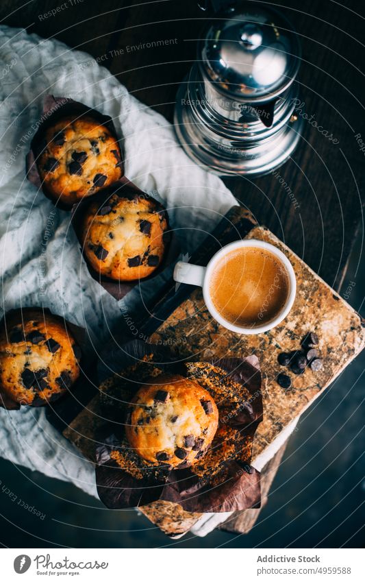 Schokoladenmuffins und Kaffeetasse auf dunklem Hintergrund gebacken Frühstück Butter Kuchen Tasse Cupcake dunkel Dessert Lebensmittel Muffin süß hölzern frisch
