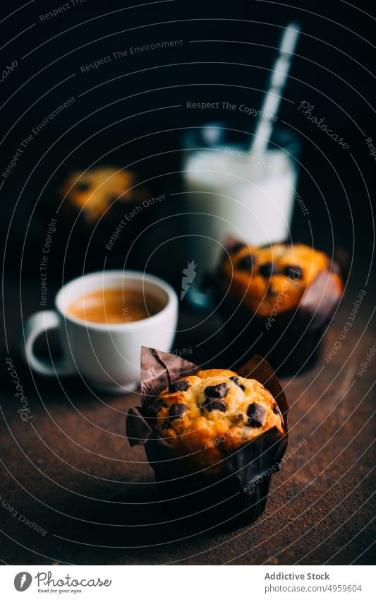 Schokoladenmuffins, Milch und Kaffeetasse auf dunklem Hintergrund gebacken Frühstück Butter Kuchen Tasse Cupcake dunkel Dessert Lebensmittel melken Muffin süß