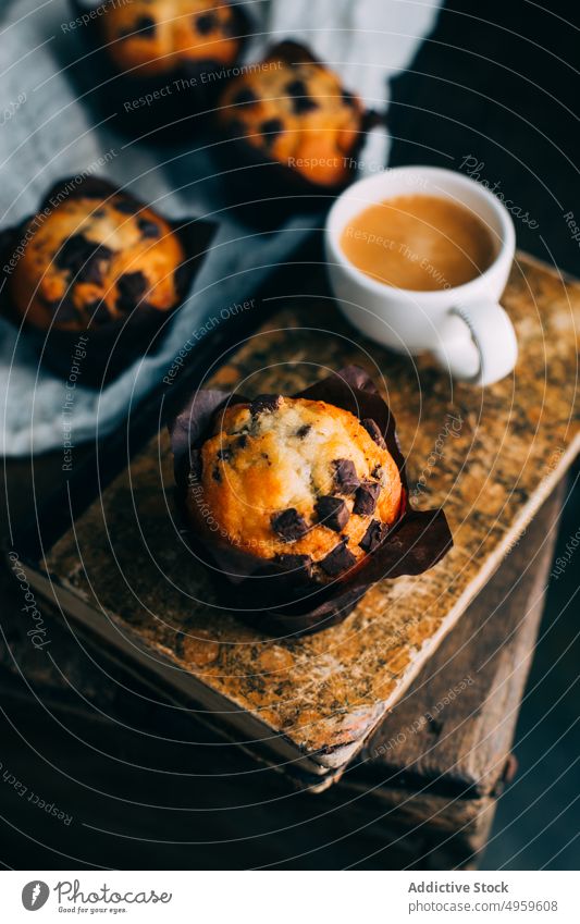 Schokoladenmuffins und Kaffeetasse auf dunklem Hintergrund gebacken Buch Frühstück Butter Kuchen Tasse Cupcake dunkel Dessert Lebensmittel Muffin süß hölzern