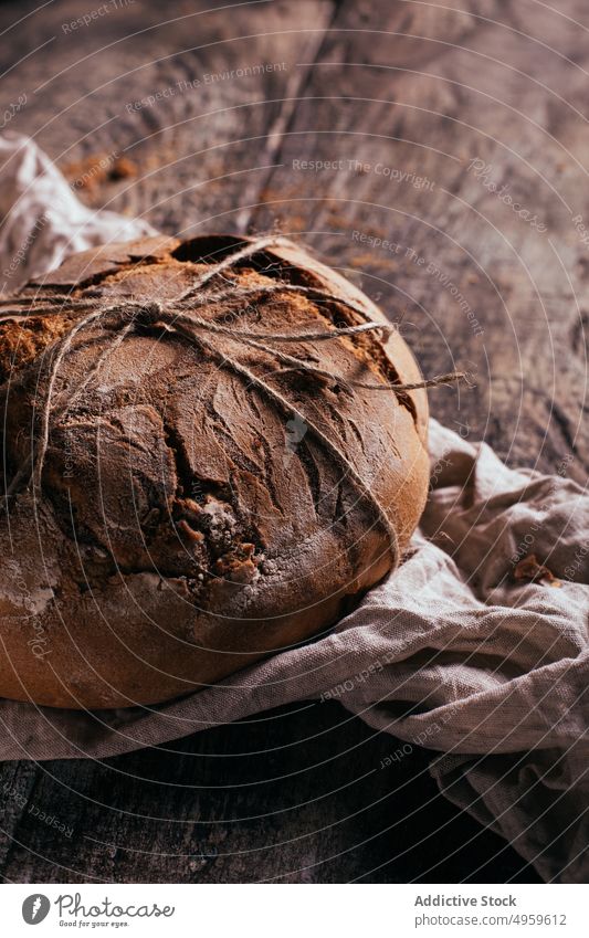 Appetitliches selbstgebackenes Brot auf einem Holzbrett mit Serviette Schneidebrett Lebensmittel Bäckerei rustikal frisch Mahlzeit lecker Küche selbstgemacht
