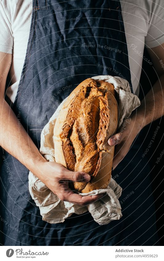Anonymer Mann zeigt knuspriges Brot in einer Bäckerei manifestieren Brotlaib lecker gebacken Ernährung Küche Knusprig frisch geschmackvoll Kunstgewerbler