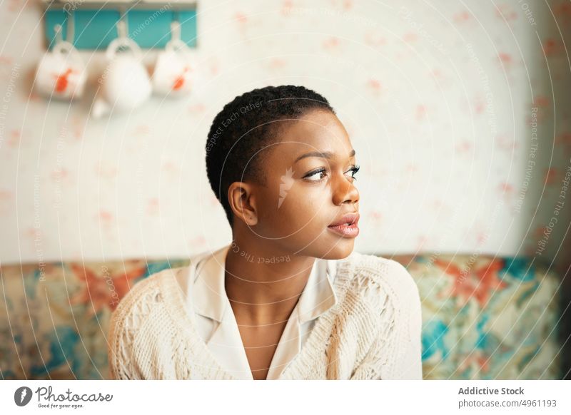 Afroamerikanische Frau mit kurzen Haaren Lifestyle aussruhen Afroamerikaner sich[Akk] entspannen Appartement Komfort heimwärts Sitzen ethnisch jung nachdenklich