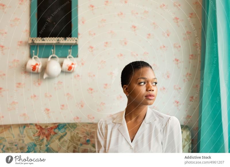 Afroamerikanische Frau mit kurzen Haaren Lifestyle aussruhen Afroamerikaner sich[Akk] entspannen Appartement Komfort heimwärts Sitzen ethnisch jung nachdenklich