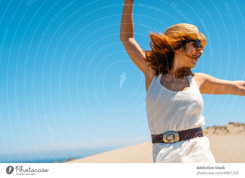 Lächelnde Frau im Kleid, die im Sommer am Sandstrand spazieren geht Strand Urlaub Meeresufer Feiertag genießen Sonnenhut Cabo de Gata Almeria heiter Spanien