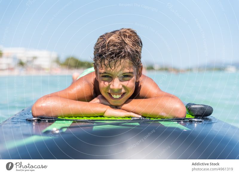 Unbekümmerter Junge auf Paddelbrett im Meer liegend MEER Zusatzplatine Sommer sich[Akk] entspannen Teenager froh sonnig Urlaub Bräune Holzplatte übersichtlich