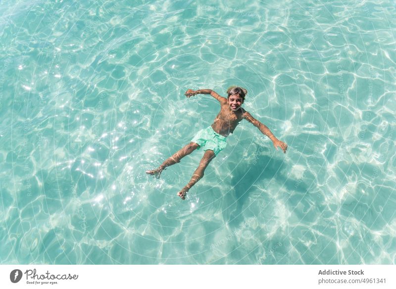 Glücklicher Teenager schwimmt im Meer Junge schwimmen MEER Sommer Urlaub heiter Feiertag genießen Lächeln sorgenfrei Optimist Freude sonnig Wasser übersichtlich