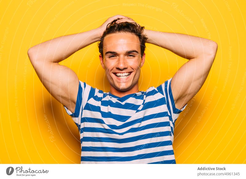 Stilvolles Modell mit modernem Haarschnitt auf gelbem Hintergrund Mann trendy Seifenblase auflehnen Streifen farbenfroh Porträt Spaß haben durchsichtig kreativ