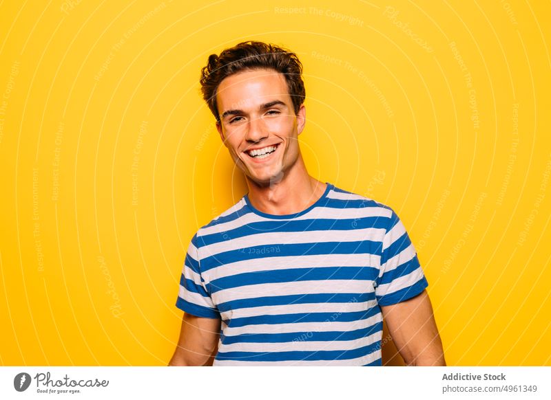 Stilvolles Modell mit modernem Haarschnitt auf gelbem Hintergrund Mann trendy Seifenblase auflehnen Streifen farbenfroh Porträt Spaß haben durchsichtig kreativ