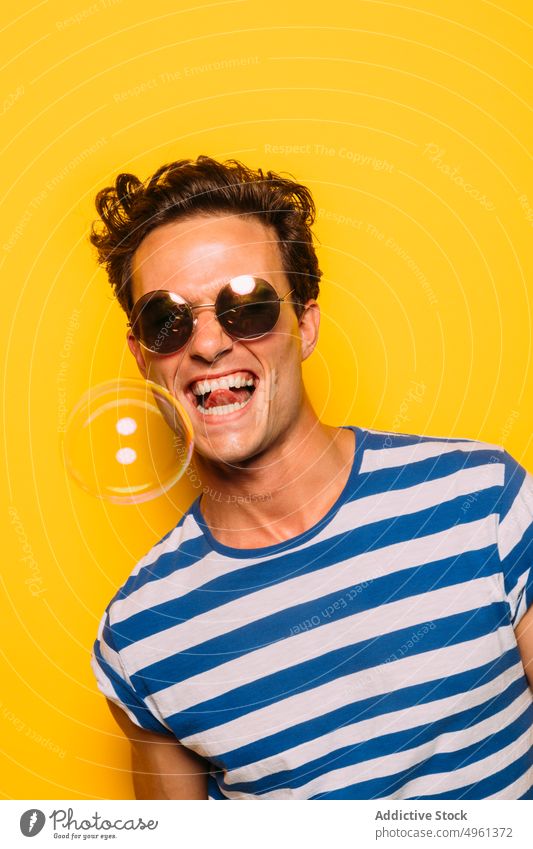 Rebellischer Mann mit moderner Sonnenbrille gegen Seifenblase Mode trendy ausspannen auflehnen Streifen farbenfroh Porträt Spaß haben durchsichtig Ornament