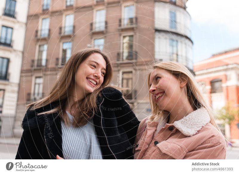Optimistische Frauen gehen in der Stadt die Straße entlang Freund Spaziergang Großstadt Lachen Spaß haben Wochenende Zusammensein Stil trendy Madrid Spanien