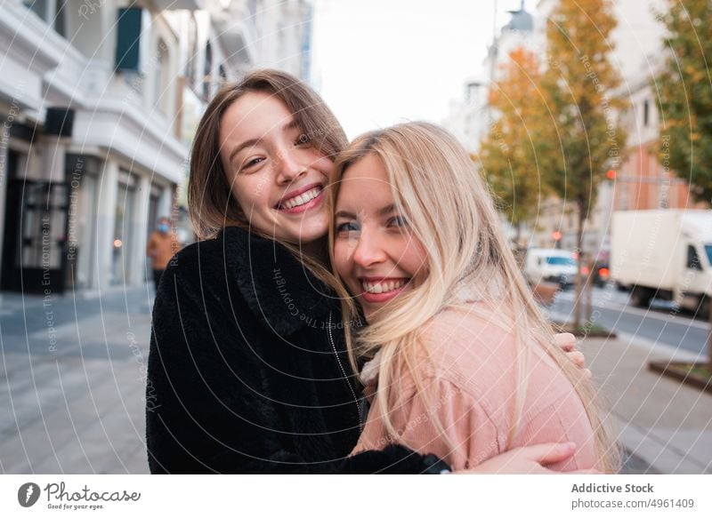 Lächelnde Freundinnen schauen in der Stadt in die Kamera Frauen bester Freund Großstadt charmant positiv Straße schlendern Wochenende Madrid Spanien jung Glück