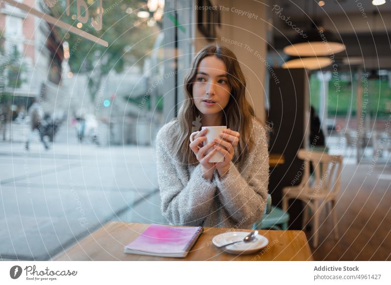 Ruhige Frau beim Chillen im Café am Wochenende Kälte Kaffee Tasse ruhig verträumt nachdenklich sich[Akk] entspannen Tisch Getränk trinken ruhen Heißgetränk jung