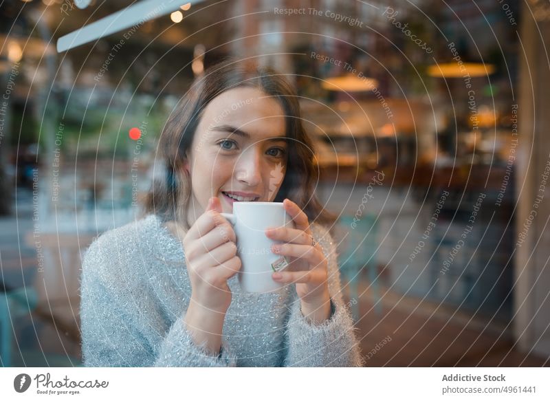 Frau trinkt Kaffee im Café trinken verträumt nachdenklich Fenster Kantine Getränk genießen lecker geschmackvoll sitzen Tisch ruhig Gelassenheit Tasse gemütlich