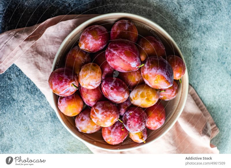 Reife Bio-Pflaumen in der Schale Schalen & Schüsseln Keramik Dessert essen Lebensmittel frisch Frucht Ernte Gesundheit organisch rosa Pflanzenbasiert purpur