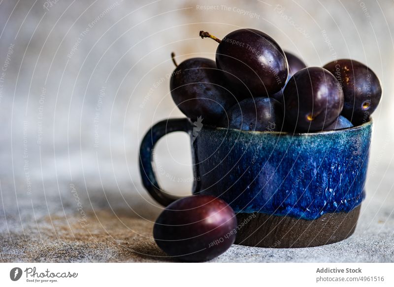 Reife Bio-Pflaumen im Keramikbecher Tasse Dessert essen Lebensmittel frisch Frucht Ernte Gesundheit Becher organisch Pflanzenbasiert reif saisonbedingt Scheibe