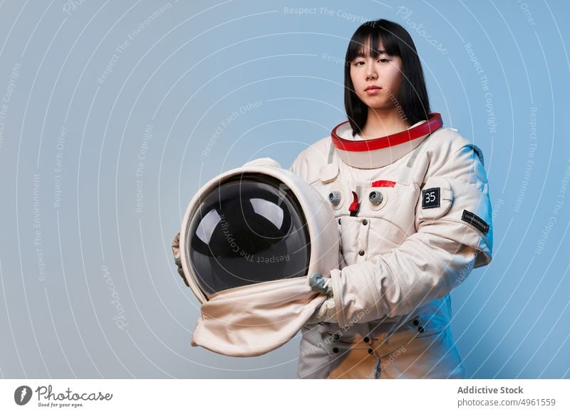 Seriöser asiatischer Astronaut mit Helm Frau Raumanzug Schutzhelm ernst Missionsstation bereit Uniform Sicherheit Porträt ethnisch Chinesisch Japanisch jung