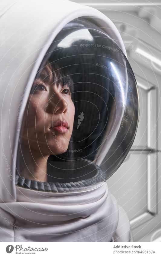 Kosmonautin im futuristischen Raumanzug Frau Astronaut Missionsstation Tracht Schutzhelm Raumschiff Mut Schmuckkörbchen behüten jung asiatisch Chinesisch