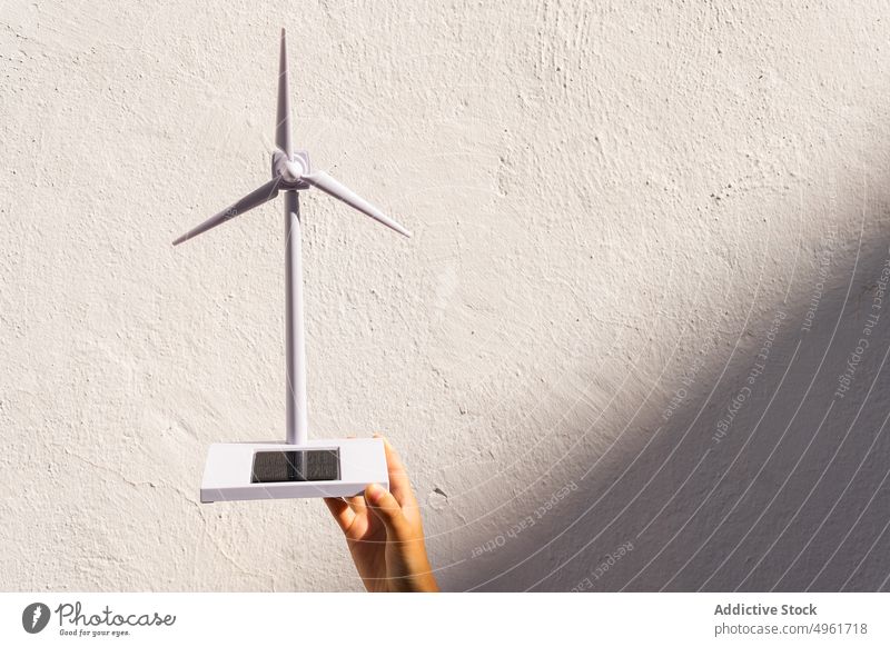 Crop anonyme Person zeigt Spielzeug Windmühle auf sonnigen Tag solar Energie Kraft Miniatur Turbine Erneuerung alternativ Propeller Hand Ökologie manifestieren
