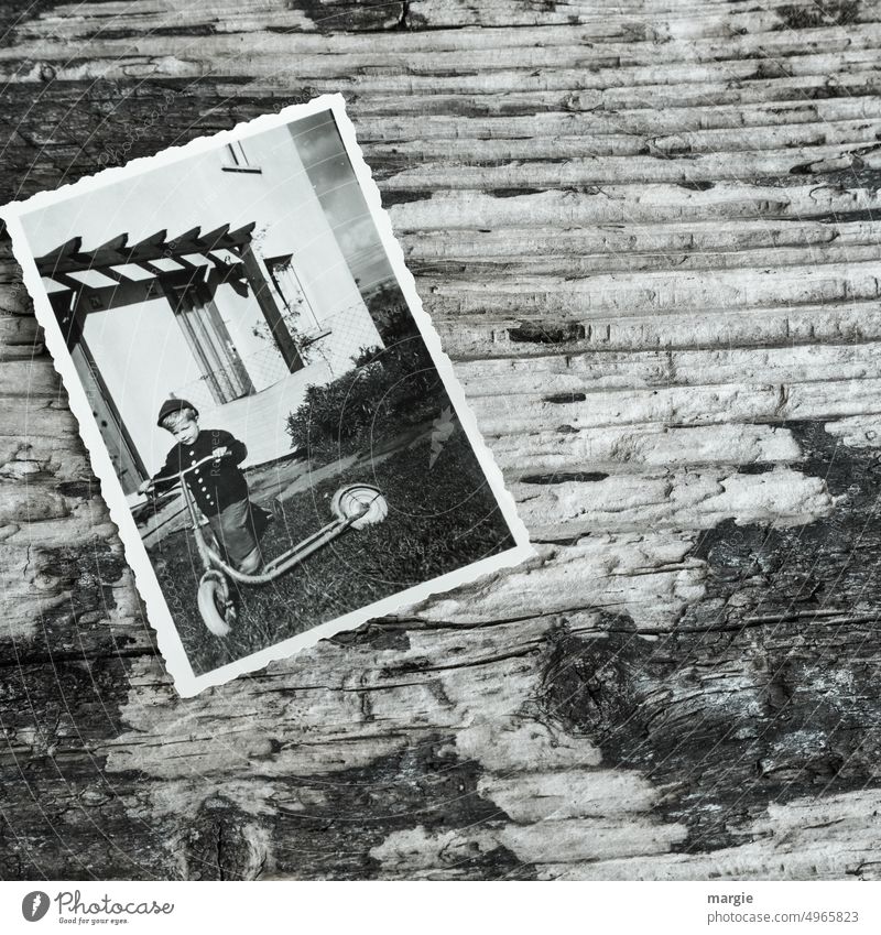 Altes Foto mit einem kleinen Jungen der einen Roller fährt Nostalgie Fotografie Kindheit Erinnerung Roller fahren Mobilität Papier analog Vergangenheit