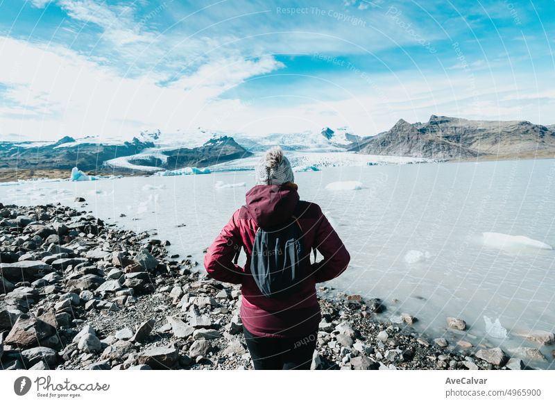 Solo Frau in Regenkleidung vor dem Jokulsarlon Gletscher. Zurück Schuss, während einer Reise Reise erkunden wilden Länder von Iceland.Adventure Urlaub gesunden Lebensstil Backpacking