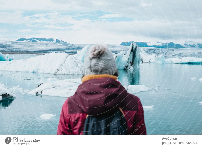 Eine Touristin steht vor der Gletscherlagune Jokulsarlon. Eisstrand, Breidamerkursandur, Diamantstrand. Reisen und die Welt erkunden als digitaler Nomade.road trip style.Copy space .