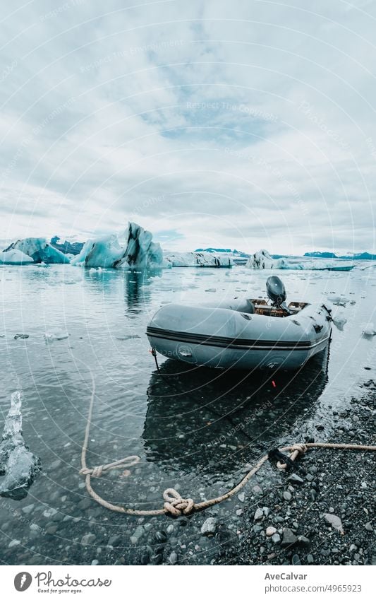 Ein Rettungsboot auf dem Jokulsarlon Gletscher Eis Nahaufnahme, Island Natur Landschaft Blick. Eisblöcke von der Gletscherlagune Jökulsárlón, Vatnajökull National Park, Island, nahe der Route 1 / Ringstraße
