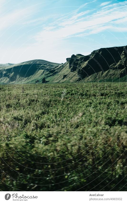 Massiver grüner Berg auf Island. Blick von der Straße während einer Reise durch isländische wilde Gebiete. Boho Backpacking Reisen Stil, Natur Hintergrund Konzept. Bunte Szenario