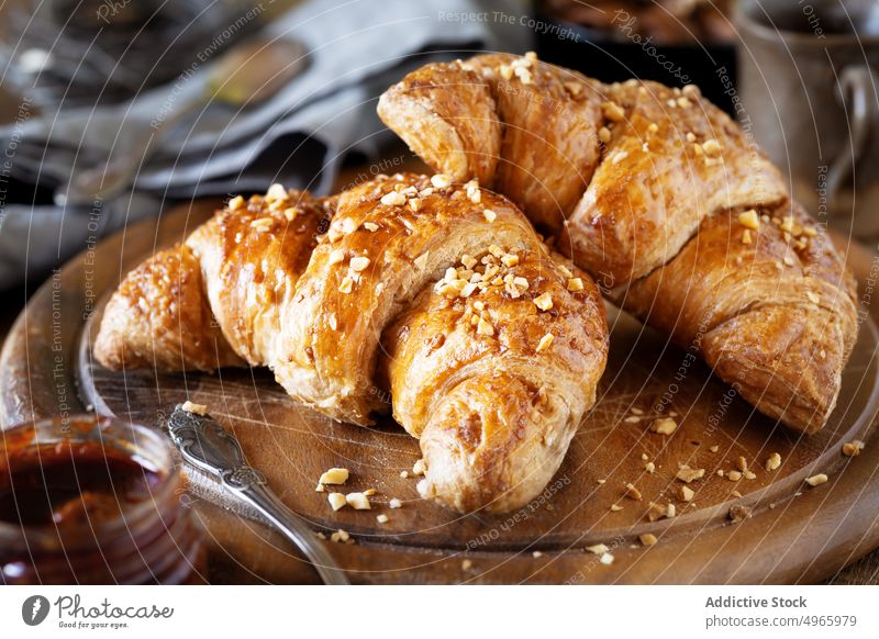 Croissants mit zerkleinerten Haselnüssen auf dem Schneidebrett Brioche Französisch Blätterteig Bäckerei Veganer Müsli Muttern Marmelade Haselnuss Morgen