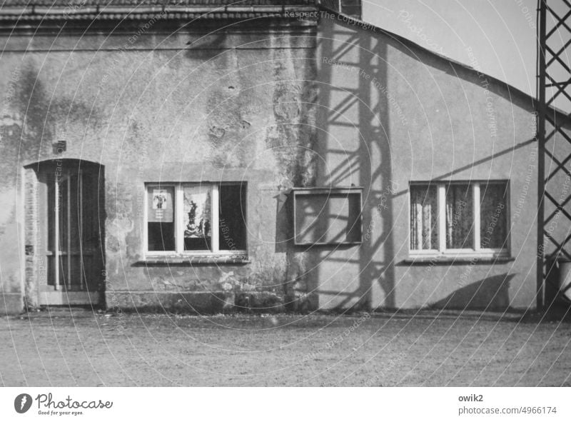 MTS früher Vergangenheit DDR Erinnerung Nostalgie analog Fotografie Vergänglichkeit Schwarzweißfoto Dorf Gebäude Baracke Tür Fenster Strommast Gestänge Schatten