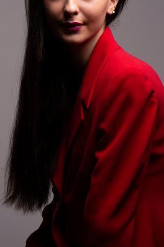 Junge Frau mit rotem Kleid attraktiv schön Schönheit Schwarzes Haar Körper Kosmetik Ohrringe Mode Mädchen Behaarung Frisur halblang Dame Lippenstift Model