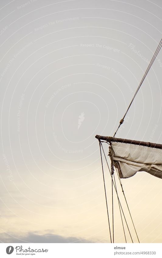 Teilansicht auf ein eingezogenes Segel eines alten Segelschiffes vor grauem Himmel Kogge Transportmittel Schifffahrt Windjammer Großsegler Karavelle Einmaster