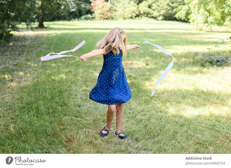 Mädchen tanzt mit Bändern in der Natur Tanzen sich im Kreise drehen Landschaft Bändchen Spaß haben Sommer Wochenende Rasen Freiheit Gras tagsüber Kind Saison