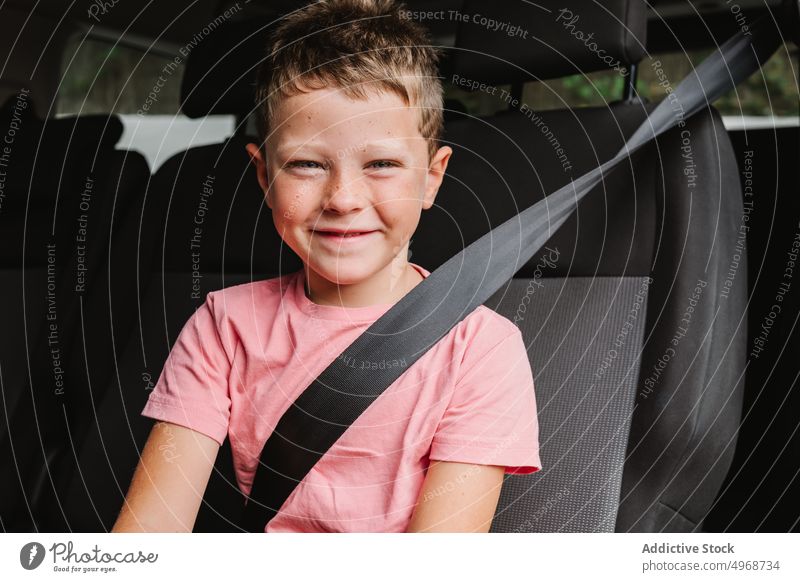 Fröhlicher Junge im Auto sitzend Lächeln Rücksitz PKW Autoreise Glück Wochenende reisen Passagier lässig Kind Reise positiv Verkehr Fahrzeug Mitfahrgelegenheit