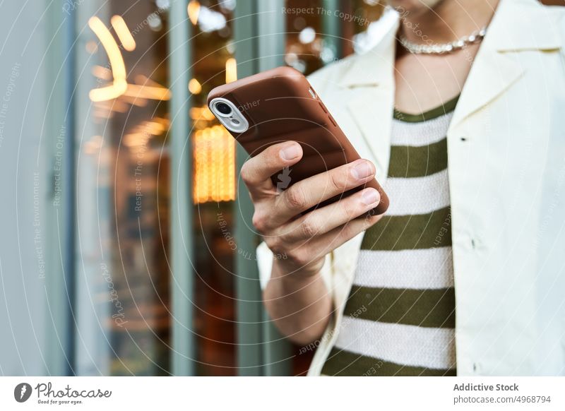 Junger Mann benutzt Smartphone auf der Straße benutzend Texten Stil Glaswand urban online modern männlich jung Textnachricht Mobile Telefon Browsen Gebäude